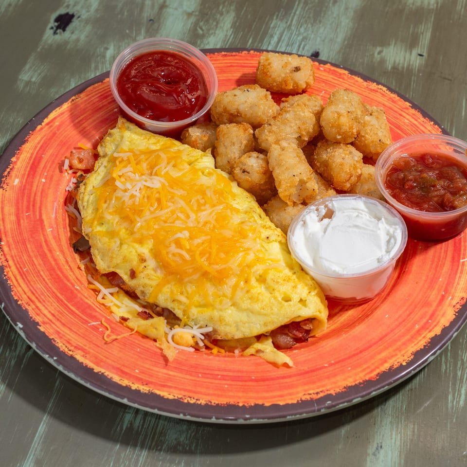 Common Ground Coffee & Eatery's omelet with cheese, tater tots, ketchup, sour cream, and salsa.